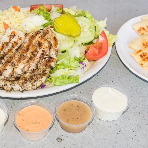 Grilled chicken with rice, salad, pita bread, and three dipping sauces from Old Time Drive In.