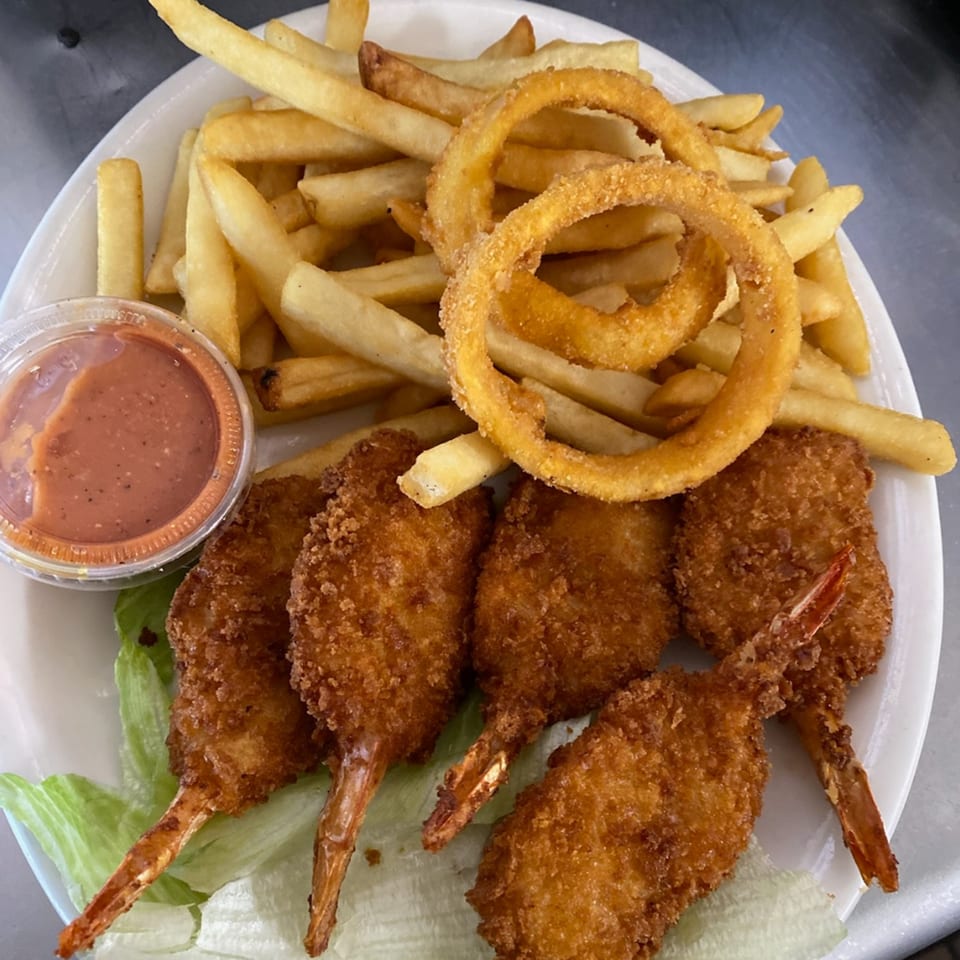 Old Time Drive In's fried shrimp and onion rings with fries and dipping sauce on a white plate.