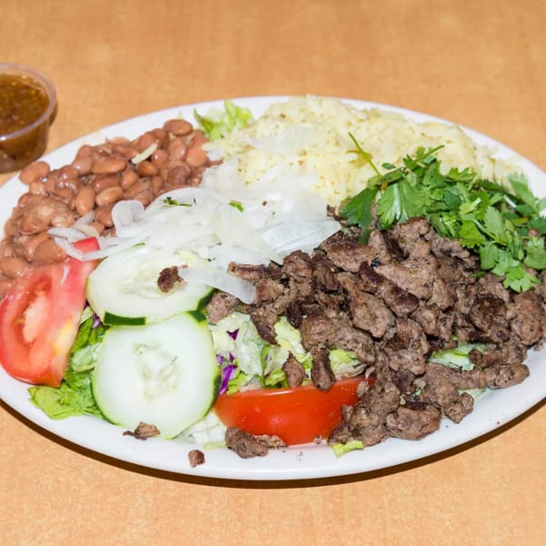 A diner plate with rice, beans, chopped meat, lettuce, tomatoes, cucumbers, onions, and cilantro.